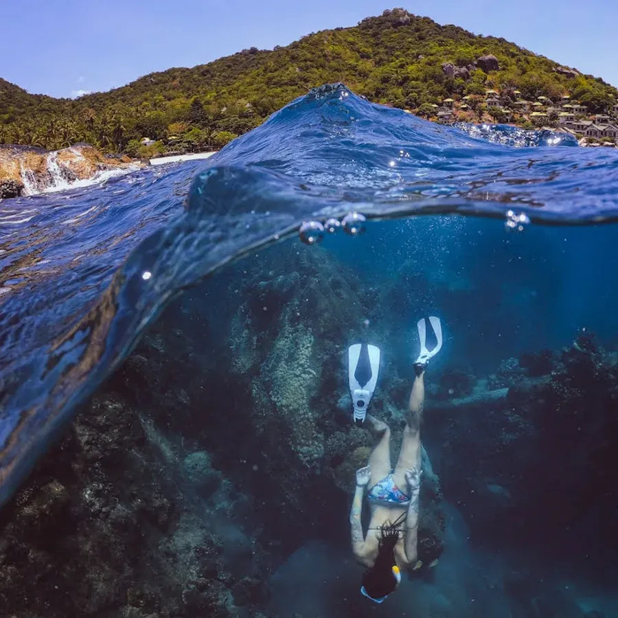 Über-Unterwasser-Aufnahme einer Schnorchlerin vor Koh Tao